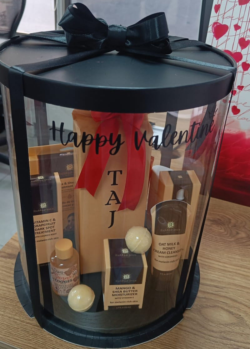 Valentine's Day gift set with products inside a black cylindrical container on a wooden surface.